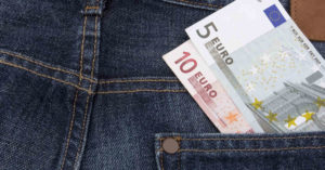 Eine Jeans, in der in einer Tasche ein 5- und ein 10-Euro-Schein steckt, als Symbol für das Eigenkapital beim Immobilienkauf | Immobilienkauf